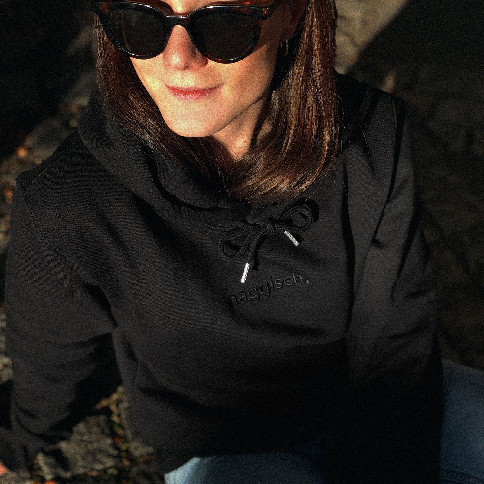 Frau mit schwarzem Kapuzenshirt schwarz bestickt mit naggisch